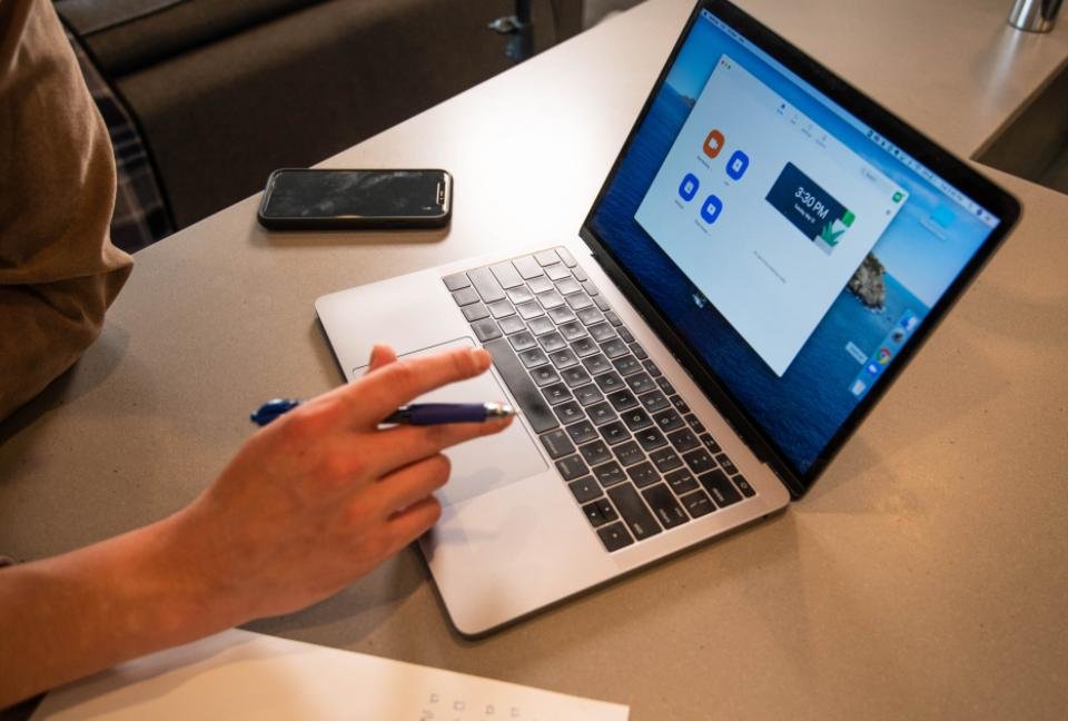 A laptop on a home desk open to a video-meeting app